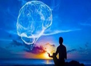 En la imagen se ve a una persona en una posición de yoga con el fondo de un atardecer y las nubes formando la figura de un cerebro